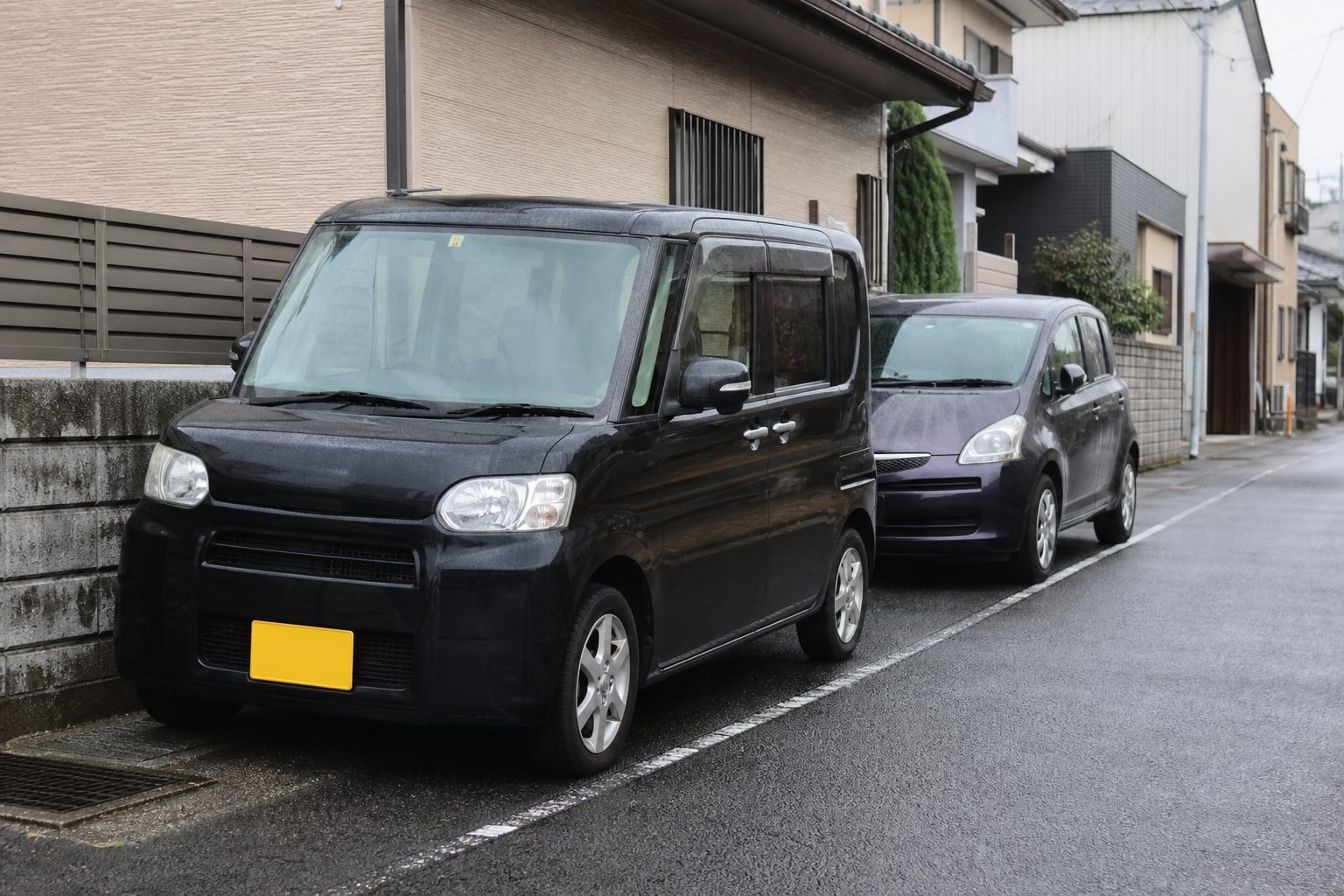 Tall Japanese kei wagon and compact minivan on a narrow residential street