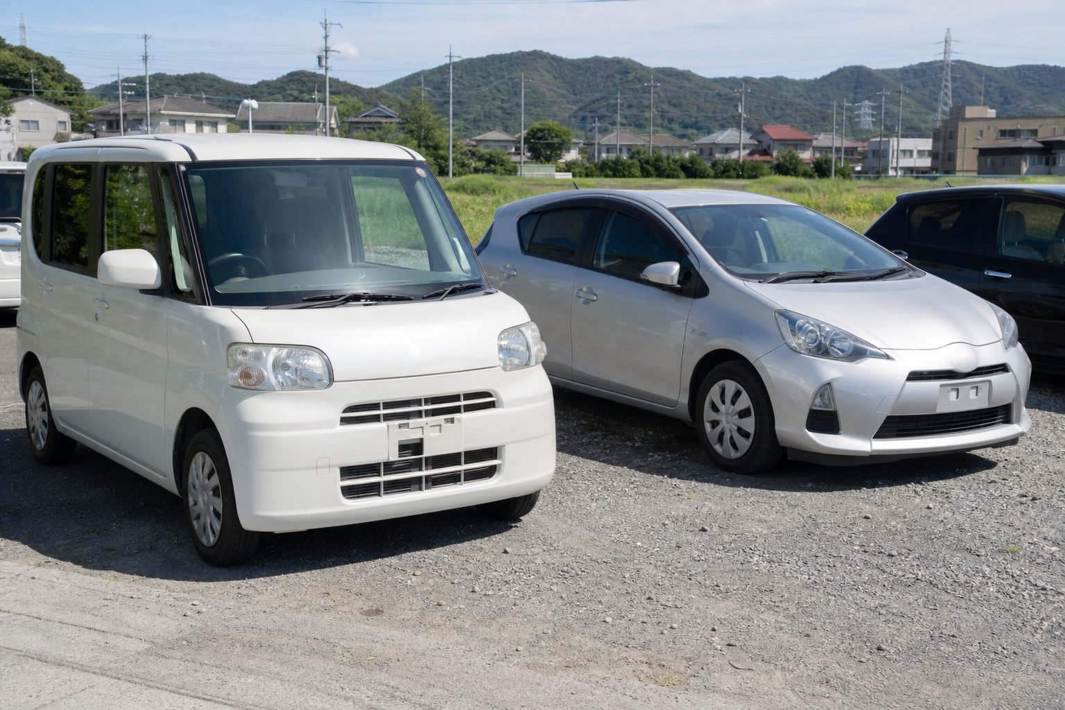 Affordable Honda N-BOX kei and Toyota Aqua hybrid on a used-car lot